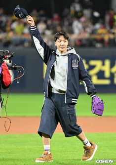 a baseball player holding his glove up in the air while standing on top of a field