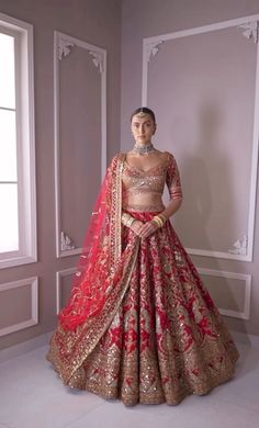 a woman in a red and gold bridal gown