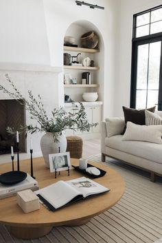 a living room filled with furniture and a fire place in front of a large window