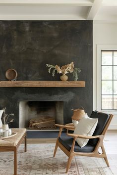 a living room filled with furniture and a fire place in front of a black wall