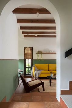 a living room filled with furniture and a yellow couch