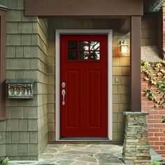 a red front door on a house with brick pillars and stone steps leading up to it