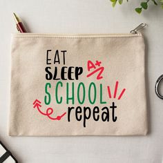 a zipper bag with the words eat sleep school repeat on it next to a pair of scissors