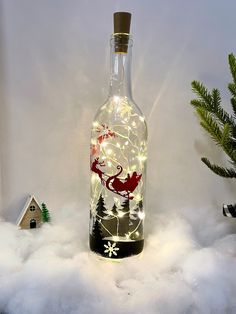 a bottle that has some lights in it and snow on the ground next to it