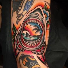 a man's arm with a shark tattoo on it