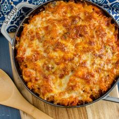 a cheesy casserole in a skillet on a wooden table