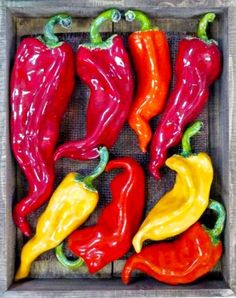 red, yellow and green peppers in a wooden box