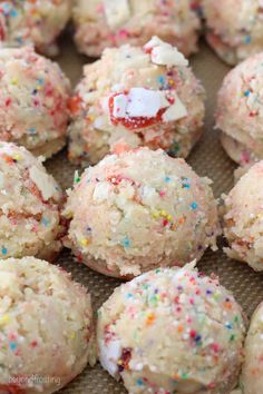 sprinkle covered cookies sitting on top of a cookie sheet