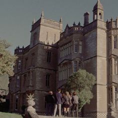 some people are standing in front of a large building