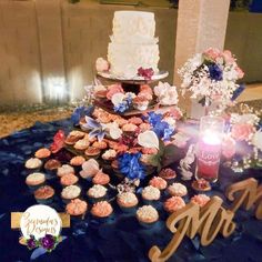 a wedding cake and cupcakes on a table