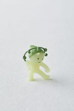 a small plastic toy with a green hat on it's head