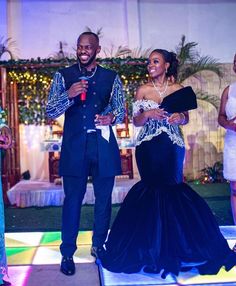 a man standing next to a woman on top of a dance floor in front of other people