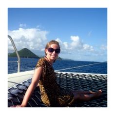 a woman sitting on top of a boat in the ocean