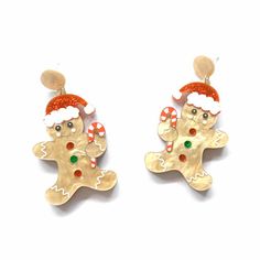 two christmas ginger earrings with santa hats and candy canes on the ear ends,