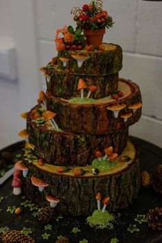 a three tiered cake made out of logs and mushrooms