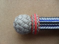 a close up of a ball on top of a roped object with red, white and blue stripes