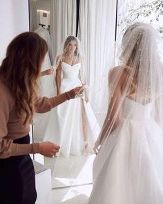 the bride is getting ready to walk down the aisle in her wedding dress and veil