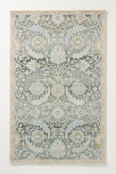 a rug with an ornate design on the front and back side, in grey tones