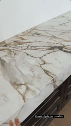 a counter top that has some kind of white marble on it and is being held up by someone's hand