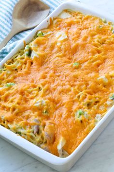 a casserole dish with broccoli and cheese in it next to a spoon