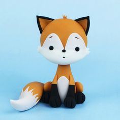 a small toy fox sitting on top of a blue surface with it's eyes closed