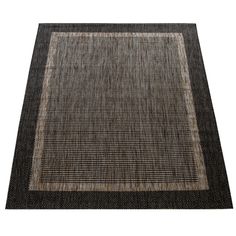 an area rug with black and white squares on the bottom, in front of a white background