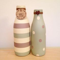 two ceramic bottles sitting next to each other on top of a wooden table with a tag