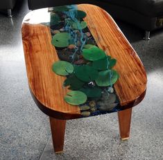 a wooden table with plants and rocks in it on the floor next to a couch