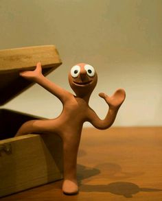 a clay figurine with eyes and arms stretched out