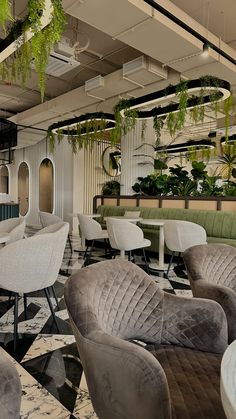 the interior of a restaurant with chairs, tables and potted plants