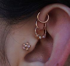 a close up of a person's ear with two piercings on top of it