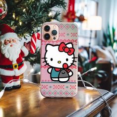 a hello kitty phone case sitting on top of a table next to a christmas tree