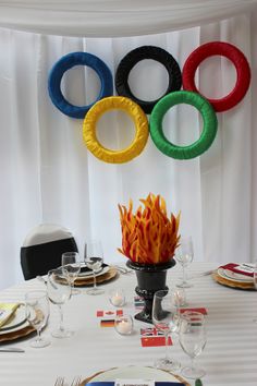 the table is set with plates and place settings for an olympic themed dinnereon party