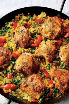 a pan filled with chicken and vegetables on top of a table