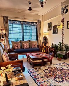 a living room filled with lots of furniture next to a window covered in curtains and lights