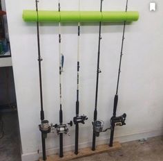 several fishing rods are lined up against the wall