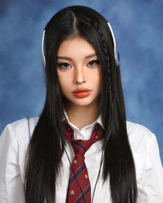 a woman with long black hair wearing a tie and headphones on her head is looking at the camera