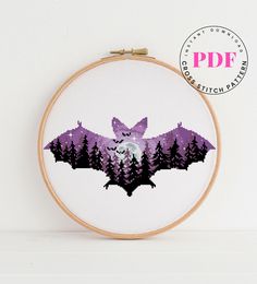 a cross stitch bat with trees in the background