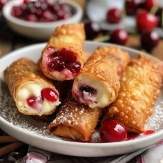 cranberry and cream filled pastries on a plate with cherries in the background