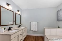 a large bathroom with two sinks and mirrors