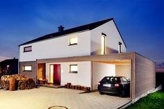 a car is parked in front of a house at night with lights on the windows