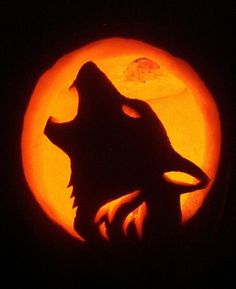 a carving of a wolf in front of a full moon