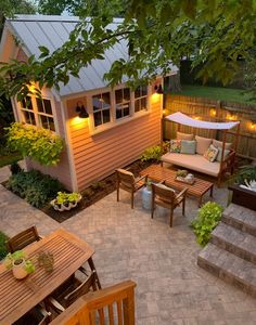 an outdoor patio with wooden furniture and lights