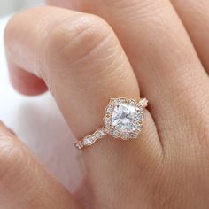 a woman's hand with a diamond ring on top of her finger and an engagement band