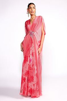 Flamingo pink draped kaftan with floral print, highlighted with floral embroidery on the waistband.
Components: 1
Pattern: Print, Embroidery
Type Of Work: Floral
Neckline: V Neck
Sleeve Type: Split Sleeves
Fabric: Crepe, Lining: Crepe
Color: Pink
Other Details: 

Model height: 5ft 8 inches, wearing size S
Note: Hair accessory worn by the model is not for sale
Occasion: Resort - Aza Fashions Festive Floor-length Kaftan With Draped Sleeves, Festive Pink Dress With Cape Sleeves, Evening Kaftan With Floral Embroidery, Elegant Floral Print Festive Kaftan, Festive Floral Print Kaftan For Party, Elegant Floral Print Kaftan For Festive Occasions, Pink Floor-length Kaftan For Festive Occasions, Pink Georgette Dress With Cape Sleeves, Silk Draped Dress With Floral Embroidery