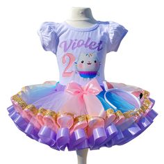 I offer you a beautiful birthday tutu outfit girls. NOTES FOR THE SELLER -Number for personalizing the top. -Name to personalize the vertex. -Need by date. Sleeve for the top - short, long. TOP. The top of it is 100% cotton. Size 3-24 months it is a bodysuit, 2T-10T it is a shirt. (Since it is more handmade always remember the shirt needs to be washed inside out, hand washed and air dried). SKIRT - made of soft tulle, edged at the bottom with a ribbon and decorated with a bow. Tutu is planted on Easter Birthday Ruffled Tutu Dress, Sweet Tulle Tutu Dress For Birthday, Playful Tutu Dress For Birthday And Easter, Playful Birthday Tutu Dress For Easter, Playful Purple Tutu Dress For Birthday, Cute Purple Tutu Dress For Birthday, Purple Cute Tutu Dress For Birthday, Gabby Birthday, Birthday Tutu Outfit