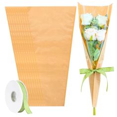 a bouquet of flowers wrapped in brown paper next to a roll of tape