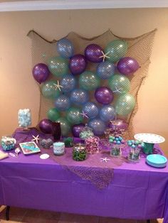 a purple table topped with lots of balloons