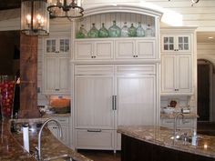 a kitchen with marble counter tops and white cabinets