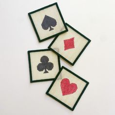 four needled playing cards are shown on a white surface